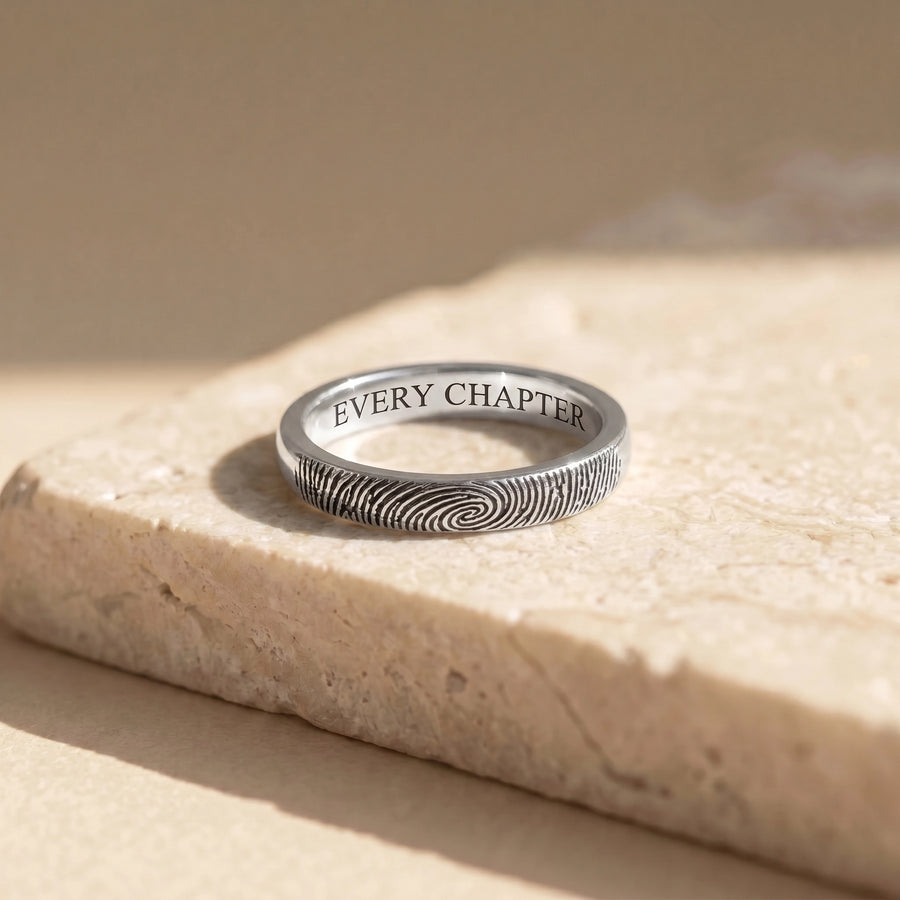 14k White Gold Fingerprint Ring on travertine marble — solid white gold, fingerprint wrap, every chapter inside