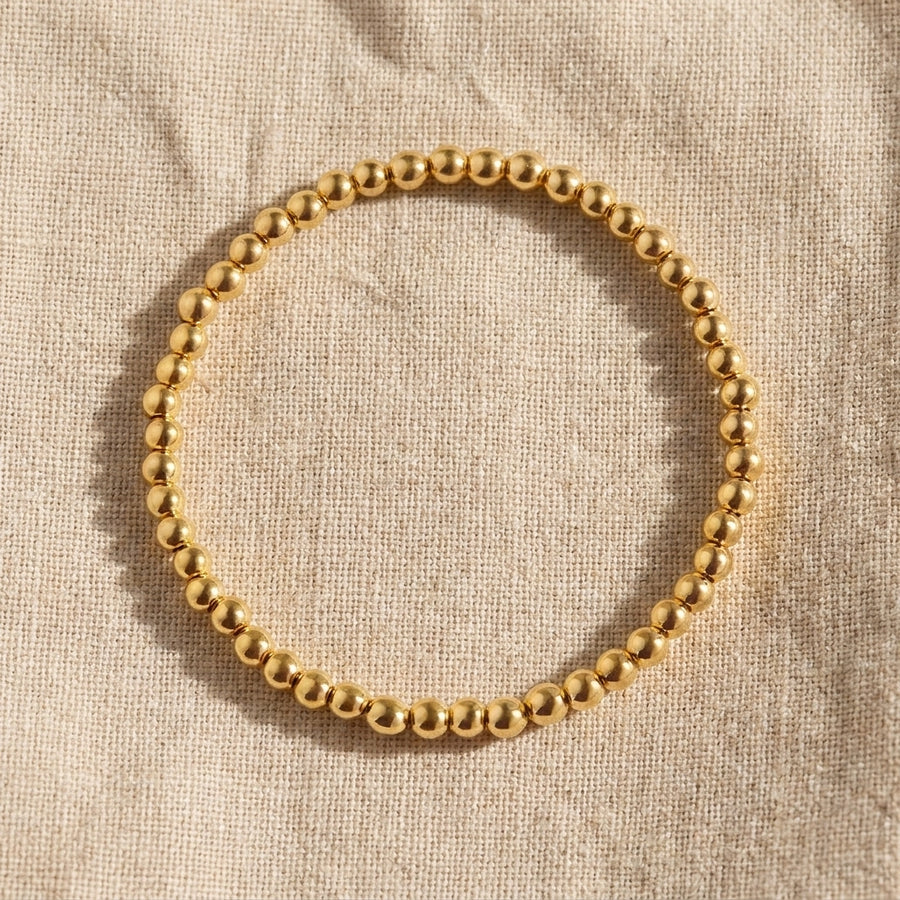 Everyday Dainty Gold Beaded Bracelet — single bracelet on linen