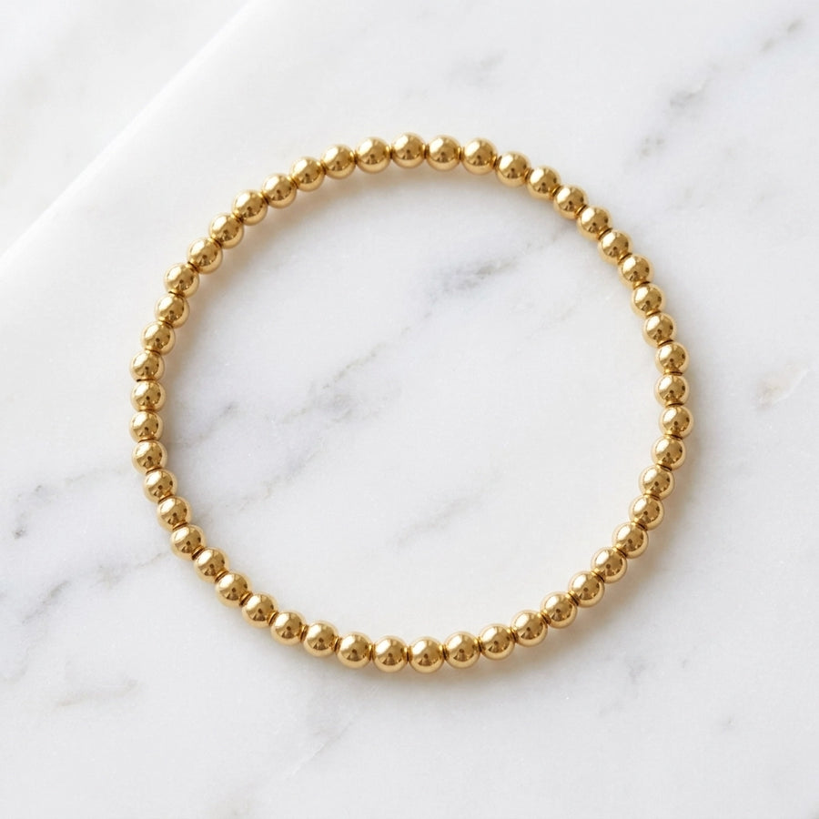 Everyday Dainty Gold Beaded Bracelet — flat lay marble