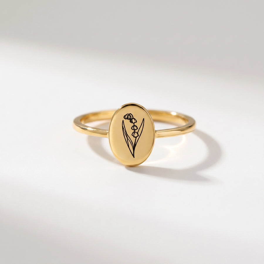 Birth Flower Engraved Ring – Clean studio shot on pearl-white background (oval gold signet, lily of the valley engraving)