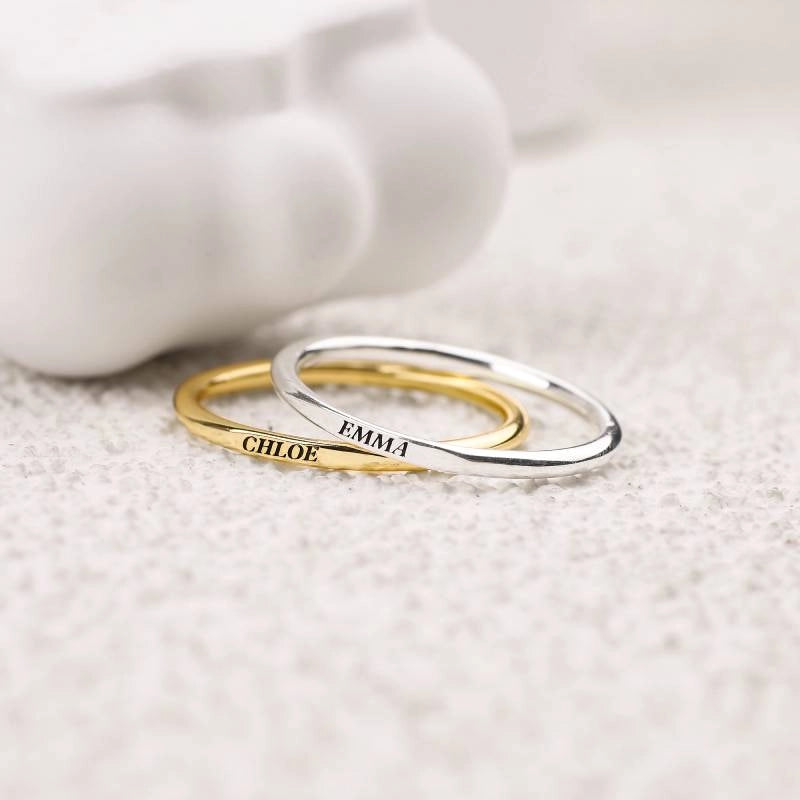 Two stackable name rings side by side — 18k gold over sterling and 925 sterling silver finishes