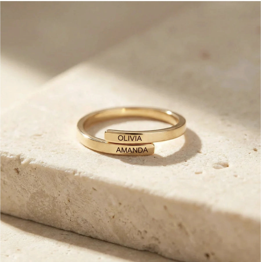Two-Name Wrap Ring in gold on travertin, engraved OLIVIA and AMANDA