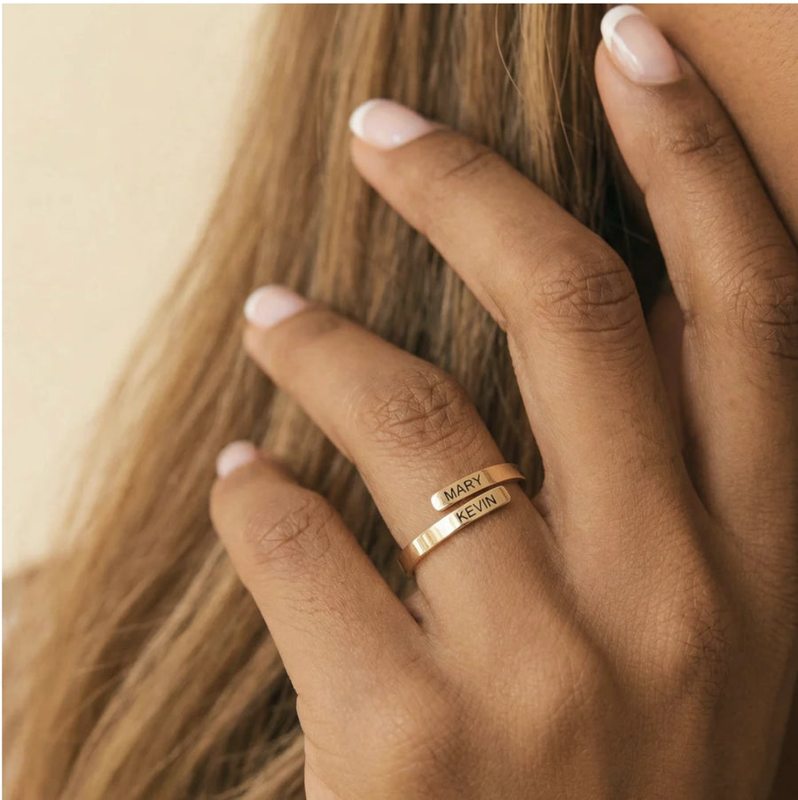 Two-Name Wrap Ring in gold on hand, engraved MARY and KEVIN