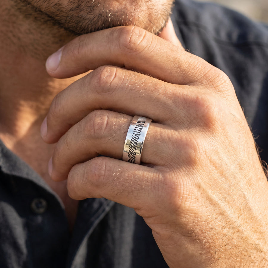 Men's slender sterling silver fingerprint ring on a man's hand brought to face