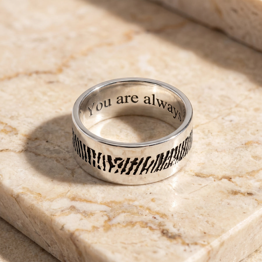 Men's slender sterling silver fingerprint ring on travertine marble flatlay