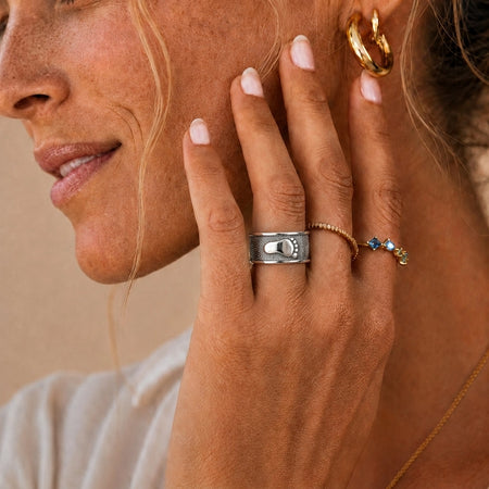 Ring Foot Print Sterling Silver Keepsakes worn on the ring finger of a mature woman in natural daylight